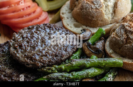 Cotto al forno funghi champignon burger con aggiunta di lattuga fresca, pomodoro, asparagi e fresche foglie di spinaci Foto Stock