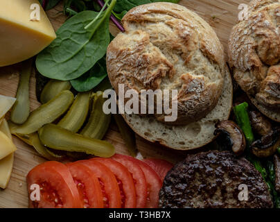 Cotto al forno funghi champignon burger con aggiunta di lattuga fresca, pomodoro, asparagi e fresche foglie di spinaci Foto Stock