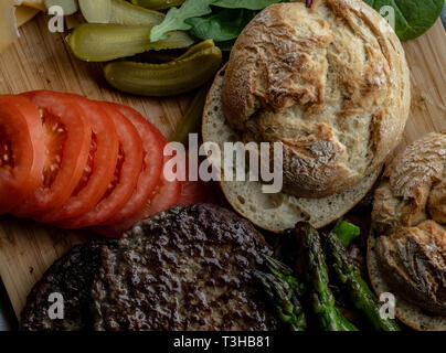 Cotto al forno funghi champignon burger con aggiunta di lattuga fresca, pomodoro, asparagi e fresche foglie di spinaci Foto Stock