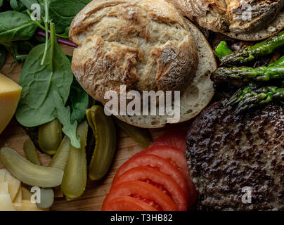 Cotto al forno funghi champignon burger con aggiunta di lattuga fresca, pomodoro, asparagi e fresche foglie di spinaci Foto Stock