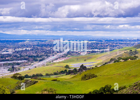 Vista verso San Jose e il Bayshore Freeway; verde delle colline in primo piano; a sud di San Jose di San Francisco Bay Area, California Foto Stock