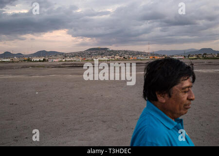 Un uomo cammina attraverso una zona di terra che una volta era parte del lago Texcoco in Chimalhuac‡n, lo stato del Messico, Messico, 24 agosto 2017. Un gruppo di residenti locali sono impegnate in una terra controversia su questa terra che chiamano ÒTlatelesÓ o Òmountain di sandÓ che il messicano del governo federale ha voluto utilizzare per il nuovo Aeroporto Internazionale di Città del Messico progetto. In messico il neo eletto presidente Andreas Manuel Lopez Obrador ha annullato questo progetto nell'autunno del 2018, mentre era al centro della costruzione. L'aeroporto è stato impostato per sostituire l'invecchiamento Benito Juarez Aeroporto Internazionale. Foto Stock