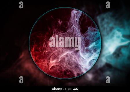 Close-up di rosso e di blu nuvola di fumo soffiato sotto una lente di ingrandimento sul nero sfondo isolato. Sfondo dal fumo di vape Foto Stock
