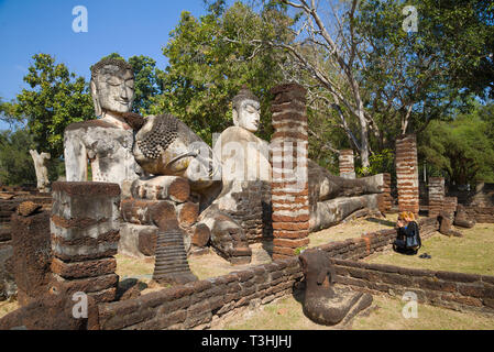 KAMPHAENG PHET, Tailandia - 30 dicembre 2016: preghiera presso le antiche statue buddiste. Le rovine del tempio buddista di Tempio di Wat Phra Kaeo Foto Stock