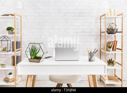 Scandinavian workplace. Laptop e florariums con piante succulente Foto Stock