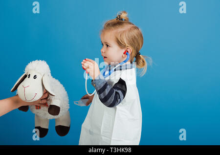 Ragazzo giocare veterinario con toy pecore madri in mano Foto Stock