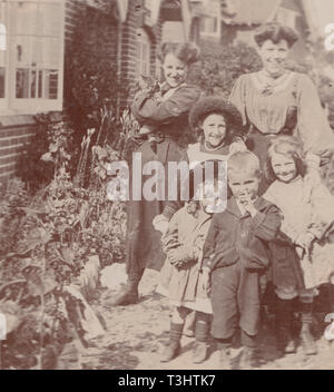 L'annata 1907 Cartolina fotografica che mostra un Edwardian famiglia da East End, Nr Lymington, Hampshire, Inghilterra. Due signore, quattro figli e un Cat. Foto Stock