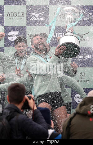 Dara Alizadeh di Cambridge celebra con il trofeo dopo gli uomini della gara in barca sul fiume Tamigi, Londra. Foto Stock