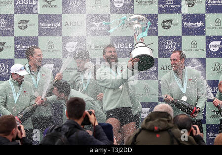 Dara Alizadeh di Cambridge celebra con il trofeo dopo gli uomini della gara in barca sul fiume Tamigi, Londra. Foto Stock