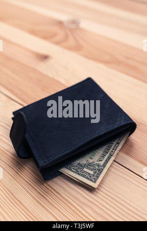 Un dollaro in portafoglio in pelle sul tavolo, il fuoco selettivo Foto Stock