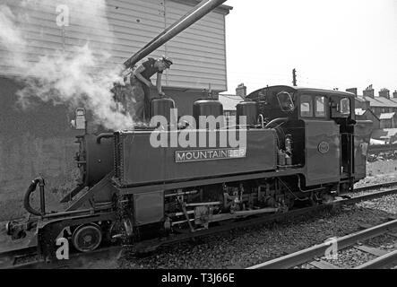 Locomotiva a vapore alpinista assunzione di acqua a Blaenau stazione ferroviaria sulla ferrovia Ffestiniog, Porthmadog a Blaenau Ffestiniog, Gwynedd, il Galles del Nord Foto Stock