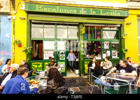 Valencia bar Spagna, gente che mangia fuori il preferito ristorante Tapas Bar Escalones de la Lonja, vista sulla strada sul marciapiede, città vecchia Valencia Spagna Europa Foto Stock