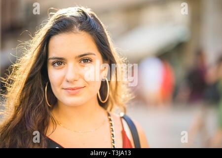 Ritratto di giovane donna bruna nella soleggiata cornice urbana, Portogallo Foto Stock