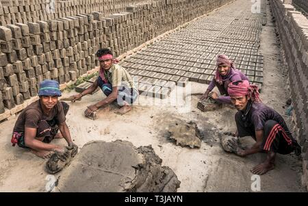 I lavoratori di una fornace di impilaggio mattoni essiccati, Dacca in Bangladesh Foto Stock