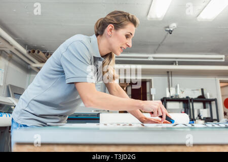 Donna segni di taglio o vinil avvolge la produzione di materiale pubblicitario Foto Stock