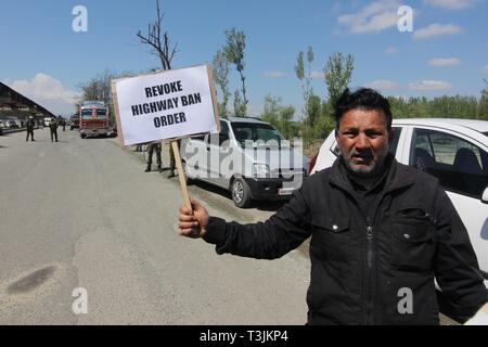 Srinagar Kashmir. 10 apr 2019. Aprile 10, 2019 - Una lavoratori della Conferenza Nazionale (a pro India partito politico ) detiene una targhetta come egli protesta contro il divieto del traffico civile di movimento da parte del governo indiano sulla periferia di Srinagar Kashmir il 10 aprile 2019. Il governo indiano ha superato un ordine di vietare il traffico civile da solcare l'autostrada principale nello Stato di Jammu e Kashmir due volte a settimana per il movimento di indiani convogli militari. (Credito Immagine: © Faisal KhanZUMA filo) Credito: ZUMA Press, Inc./Alamy Live News Foto Stock