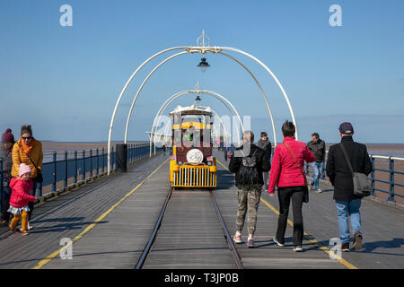 Famiglie che camminano sul molo a Southport, Regno Unito. 10th aprile 2019. Meteo Regno Unito. Soleggiato ma artico chill sulla costa con venti orientali portando basse temperature per gli escursionisti sul molo di mare. Credit: MediaWorldImages/Alamy Live News Foto Stock