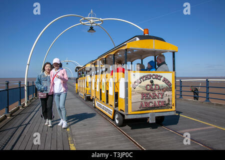 Famiglie che camminano sul molo a Southport, Regno Unito. 10th aprile 2019. Meteo Regno Unito. Soleggiato ma artico chill sulla costa con venti orientali portando basse temperature per gli escursionisti sul molo di mare. Credit: MediaWorldImages/Alamy Live News Foto Stock