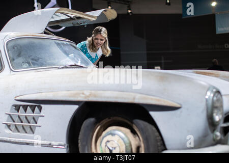 Essen, Germania. Decimo Apr, 2019. Alla Techno Classica, modello Alida sorge nella parte anteriore di una Mercedes-Benz 300 SL del portellone ad ala di gabbiano dal 1954. La fiera mondiale si svolge dal 10 al 14 aprile. Credito: Marcel Kusch/dpa/Alamy Live News Foto Stock