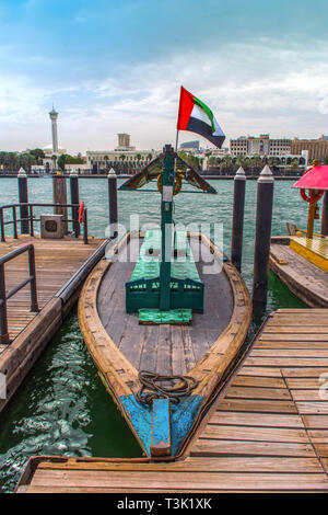 Tradizionale giro in barca Abra Dubai Deira Creek, luogo da visitare in Dubai lago blu con battenti bandiera degli EMIRATI ARABI UNITI Foto Stock