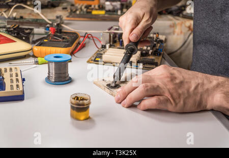 Il tecnico elettricista prepara rosin saldatoio per lavoro Foto Stock