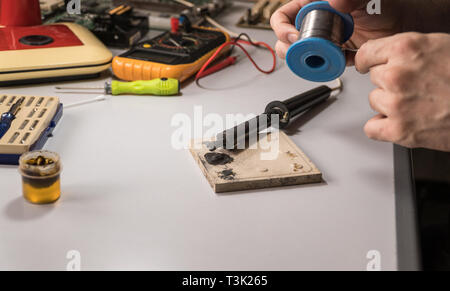 Il tecnico elettricista prepara rosin saldatoio per lavoro Foto Stock