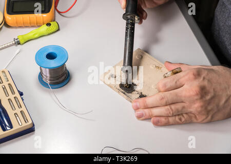 Il tecnico elettricista prepara rosin saldatoio per lavoro Foto Stock