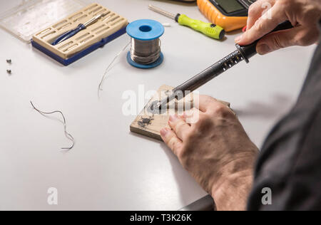 Il tecnico elettricista prepara rosin saldatoio per lavoro Foto Stock