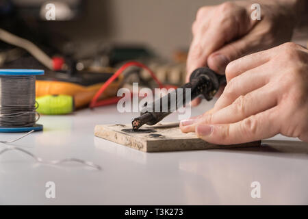 Il tecnico elettricista prepara rosin saldatoio per lavoro Foto Stock