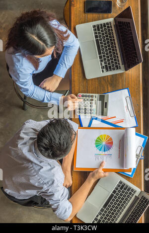 Giovani dipendenti aziendali discutere circa il numero finanziario sul documento Foto Stock