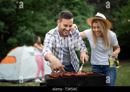 I giovani di sesso maschile e femminile giovane la cottura barbecue in natura Foto Stock