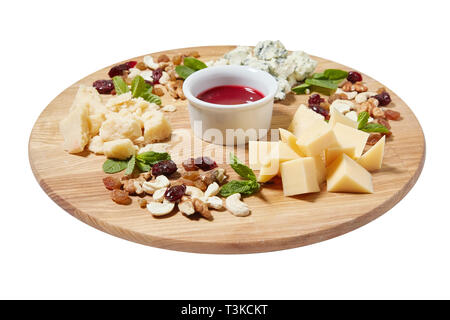 Piatto di formaggi antipasti con formaggio italiano misto, anacardi, foglie di menta fresca, noci, uvetta su tavola di legno su fondo bianco, Foto Stock