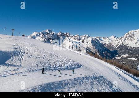 Gli sciatori e gli snowboarder in pista, stazione di sci delle Alpi italiane. La Valtellina. Foto Stock