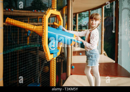 Bambina gioca con una pistola ad aria compressa nei bambini di Game Center Foto Stock
