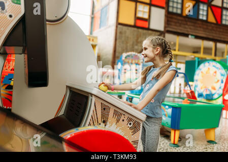 Bambina gioca sul video macchina di gioco Foto Stock