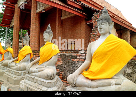 Fila di immagini di Buddha di fronte al municipio di ordinazione di Wat Yai Chai Mongkhon tempio, Ayutthaya sito archeologico, Thailandia Foto Stock