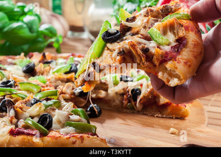 Pizza piccante con pollo gyros, peperone verde, olive e cipolla sul tagliere Foto Stock