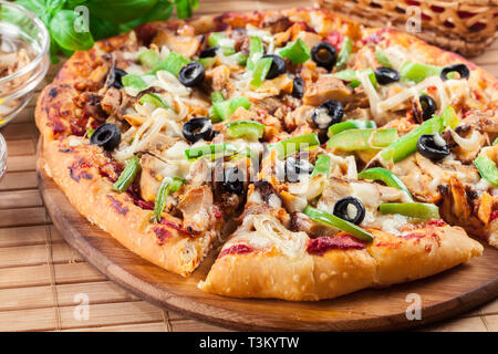 Pizza piccante con pollo gyros, peperone verde, olive e cipolla sul tagliere Foto Stock