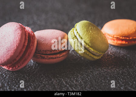 Macaron colorati su sfondo scuro Foto Stock