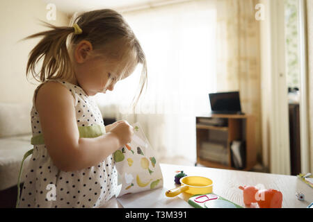 Bambina gioca in casa con i giocattoli Foto Stock