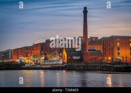 L'Albert Dock edifici complessi nella luce della sera con vapore tug il Daniel Adamson ormeggiato nel dock di inscatolamento. Foto Stock