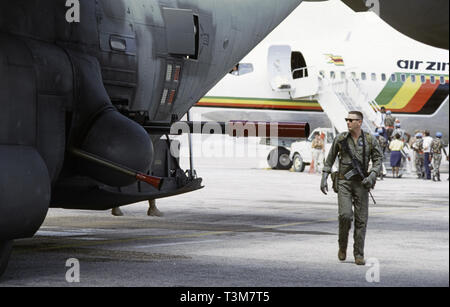 30 ottobre 1993 il Maestro Sergente William B. Walter passa il barile sporgente di un Howitzer da 105mm e la pistola Bofors da 40mm della sua nave da tiro USAF Lockheed AC-130H 'Spectra', all'aeroporto di Mogadiscio, in Somalia. Foto Stock