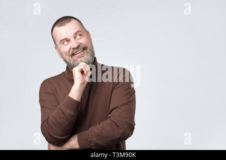 Maturo uomo barbuto cercando e pensare al futuro. Foto Stock