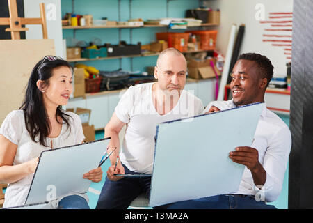 Tre studenti d'arte vernice in un corso di pittura della International art college Foto Stock