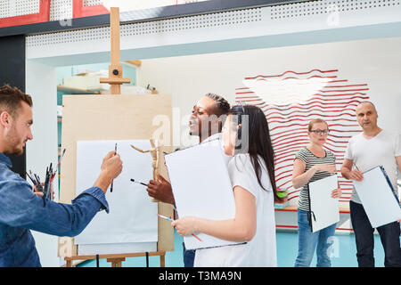 Gli studenti paint insieme in un dipinto di classe ad un cavalletto all'Accademia delle Belle Arti Foto Stock
