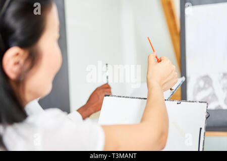 La donna come un principiante o arte studente apprende il dipinto in un corso presso la community college Foto Stock