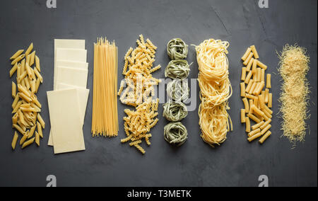 Diversi tipi di pasta dalla varietà di frumento duro per la cottura di piatti mediterranei. Vista superiore, lo spazio per il testo. Foto Stock