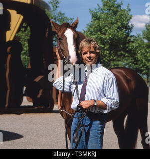 Thomas Fritsch, deutscher Schauspieler und Synchronsprecher, mit Pferd, Deutschland ca. 1987. Attore tedesco e doppiaggio attore Thomas Fritsch con un cavallo, Germania ca. 1987. Foto Stock