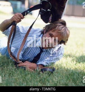 Thomas Fritsch, deutscher Schauspieler und Synchronsprecher, mit Pferd, Deutschland ca. 1987. Attore tedesco e doppiaggio attore Thomas Fritsch con un cavallo, Germania ca. 1987. Foto Stock