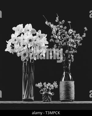 Bouquet di rami fioriti di Willow e sanguinello in un vaso, bouquet di fiore di narciso e bouquet di fiori bluebell in un vaset sul tavolo su un Foto Stock